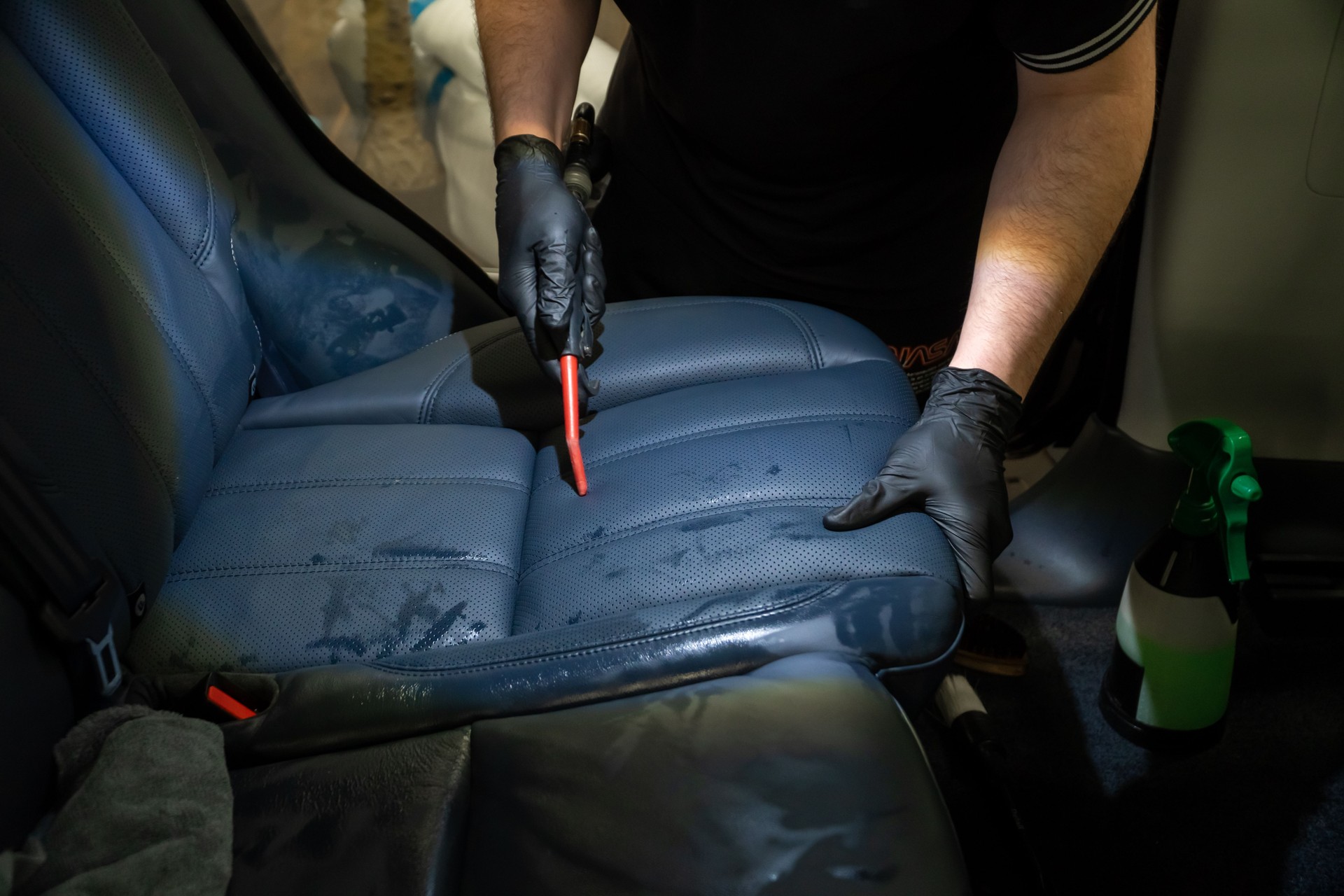 The detailing master cleans the car interior with a hot steam cleaner close-up. Dry cleaning of the car interior, close-up, selective focus. Car detailing and the concept of car interior care.